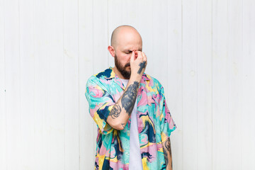 bald man feeling stressed, unhappy and frustrated, touching forehead and suffering migraine of...