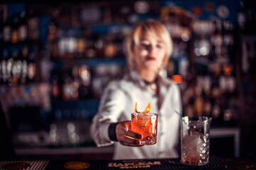 Girl barman makes a cocktail on the public house
