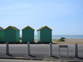 Sea road sign, street, coastal colorful sheds and sea