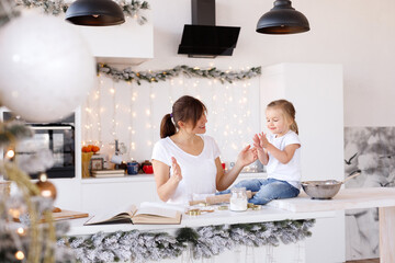 Mom and daughter cook cookies at home on Christmas Day