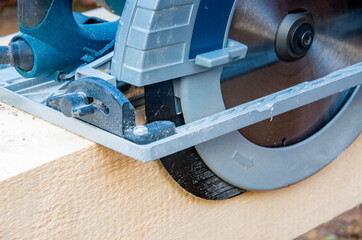 Detailed view Hand circular saw on wooden beams