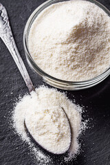 granulated milk powder on a dark stone background