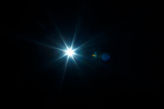 Easy to add lens flare effects for overlay designs or screen blending mode to make high-quality images. Abstract sun burst, digital flare, iridescent glare over black background.
