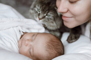 Adorable child in a white sunny bedroom. Baby is resting in bed. Family morning at home. Loving mom...