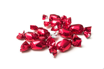Closeup of chocolate candies in a red paper on white background