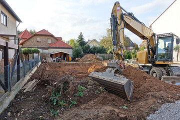 Bagger vor einer Baugrube zum Bau eines Wohnhauses