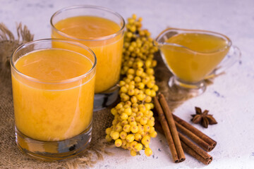 Useful sea buckthorn fruit drink with honey in glasses.
Close-up.