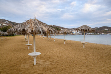 Straw umbrellas on sandy beach of Chora on Ios Island. Cyclades, Greece