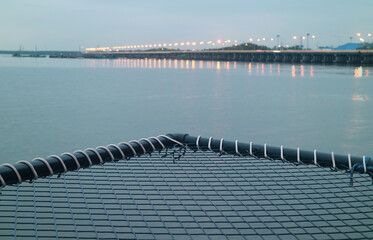 Fototapeta na wymiar Closeup Empty Over-water Hammock Bed with Blurry Sea Bridge in the Backdrop