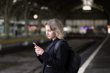 Fototapeta premium girl using mobile phone at the train station