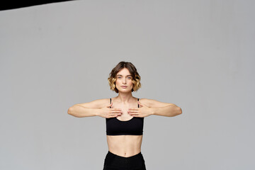 Fototapeta na wymiar Sporty woman in leggings on a gray background is engaged in fitness Copy Space