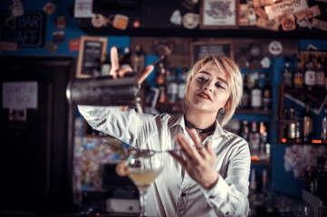 Charming girl bartender demonstrates his professional skills at bar