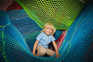 Portrait of little boy having fun and playing in the entertainment park
