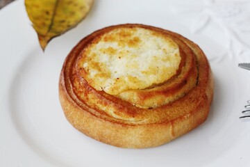 Delicious bun with cottage cheese on a wooden table 