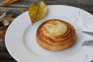 Delicious bun with cottage cheese on a wooden table 