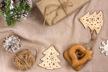 New Year's composition. Gingerbreads, gift wrapped in paper and Christmas decorations on a beige background. Christmas, winter, new year concept. Flat lay, top view with copy space.