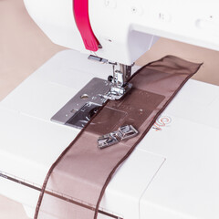 Sewing machine sews tape. Close up