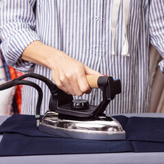 Woman ironed trousers. Concept of Housewives