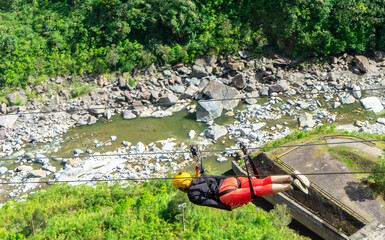 Ecuador, near Banos on the road of Waterfalls. Zip-lining over the the canyon near the Road of...