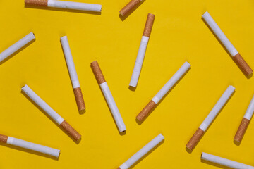 Background from many cigarettes on yellow bright background.