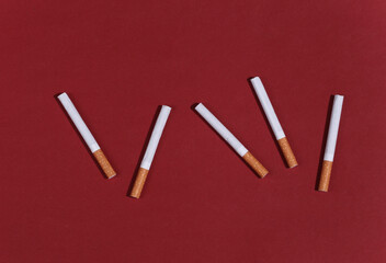 Many cigarettes on red bright background.