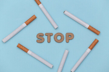 Cigarettes on a blue background with the word stop. Quit smoking