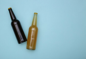 Bottle of light and dark beer on a blue background. Copy space