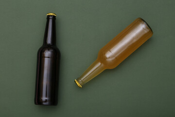 Bottle of light and dark beer on green background. Top view