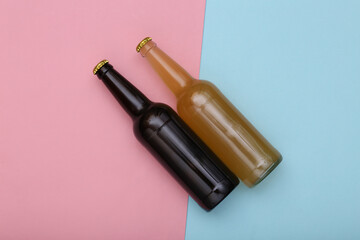 Bottle of light and dark beer on pink blue background. Top view