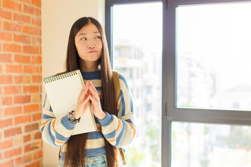 young asian woman scheming and conspiring, thinking devious tricks and cheats, cunning and betraying