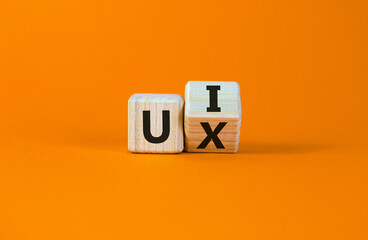 UX design or UI design. Turned cube and changed the words 'UX' to 'UI'. Beautiful orange background. Business concept. Copy space. - Powered by Adobe