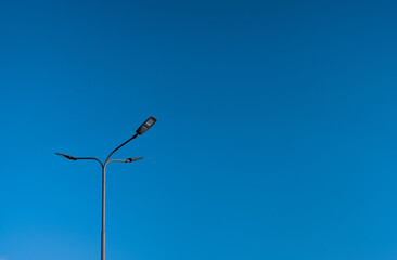 The street light pole with a blue sky background - Automatic street twin lamp against the blue sky with copy space