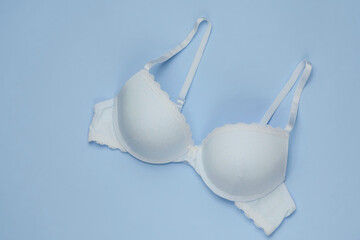 Stylish bra on blue pastel background. Top view. Beauty and fashion minimalistic still life