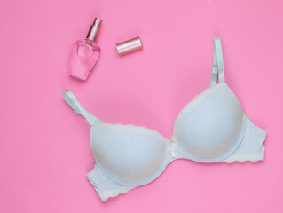 Stylish bra, perfume bottle on pink pastel background. Top view. Beauty and fashion minimalistic still life