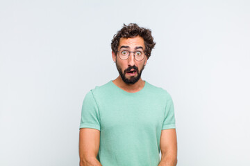 young bearded man feeling terrified and shocked, with mouth wide open in surprise