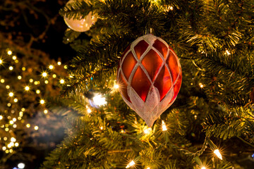 Christmas tree ornament hanging from a branch on an evergreen
