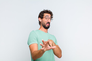 young bearded man feeling disgusted and nauseous, backing away from something nasty, smelly or...