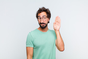 young bearded man looking serious and curious, listening, trying to hear a secret conversation or...