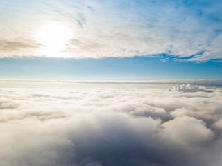 Aerial view. Flying over white clouds during the day in sunny weather.