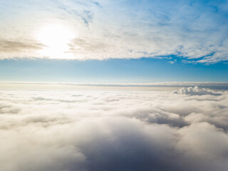 Aerial view. Flying over white clouds during the day in sunny weather.