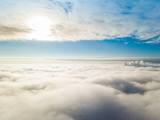 Fototapeta na wymiar Aerial view. Flying over white clouds during the day in sunny weather.