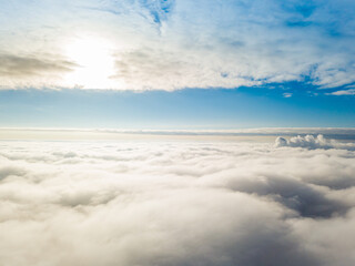 Aerial view. Flying over white clouds during the day in sunny weather.