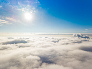 Aerial view. Flying over white clouds during the day in sunny weather.