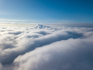 Aerial view. Flying over white clouds during the day in sunny weather.