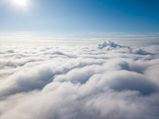 Aerial view. Flying over white clouds during the day in sunny weather.