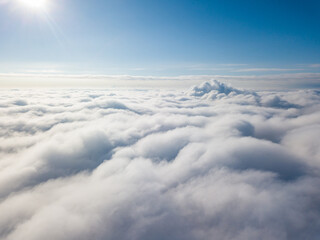 Aerial view. Flying over white clouds during the day in sunny weather.