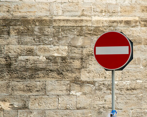 No entry road sign on the background of an old brick wall