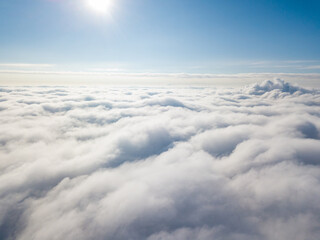 Aerial view. Flying over white clouds during the day in sunny weather.