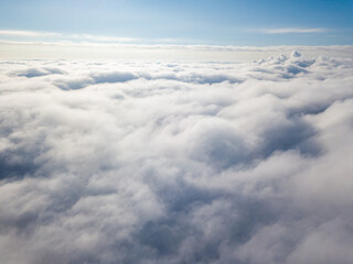 Aerial view. Flying over white clouds during the day in sunny weather.