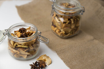 Homemade crispy sun dried organic apple slices. Close up of apple chips with spice in glass jar isolated on white background with copy space for text
